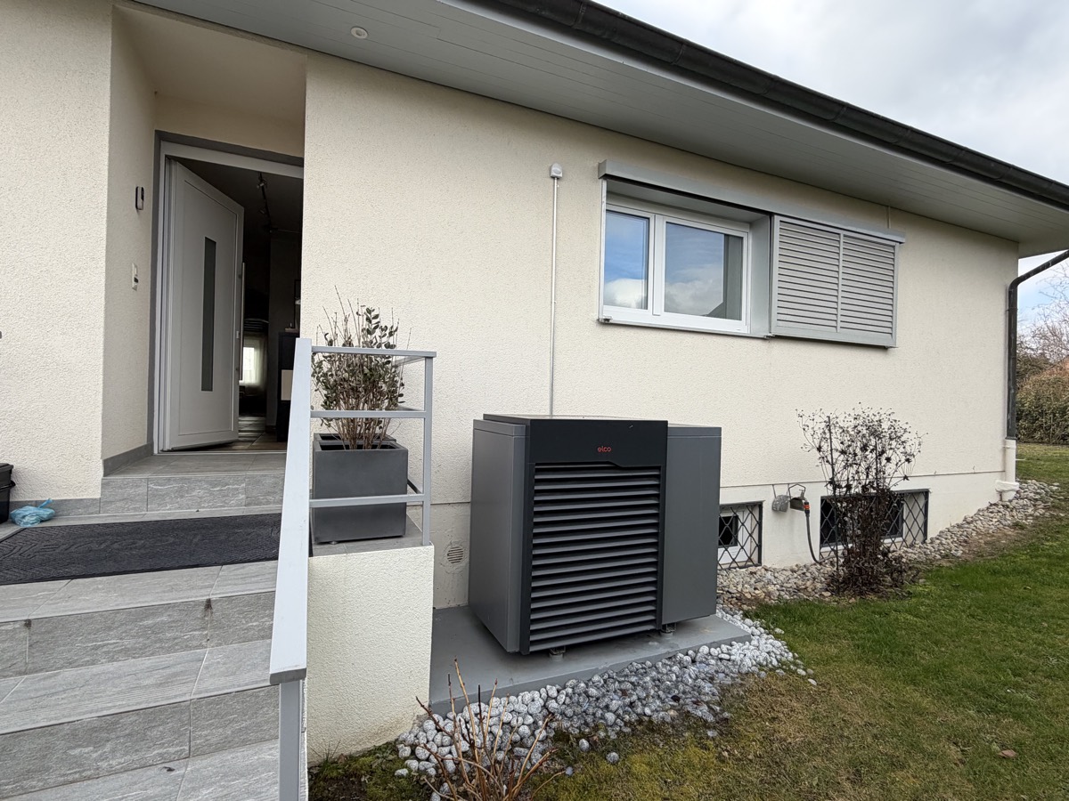 Unité extérieure de pompe à chaleur air eau installée contre la façade d'une villa