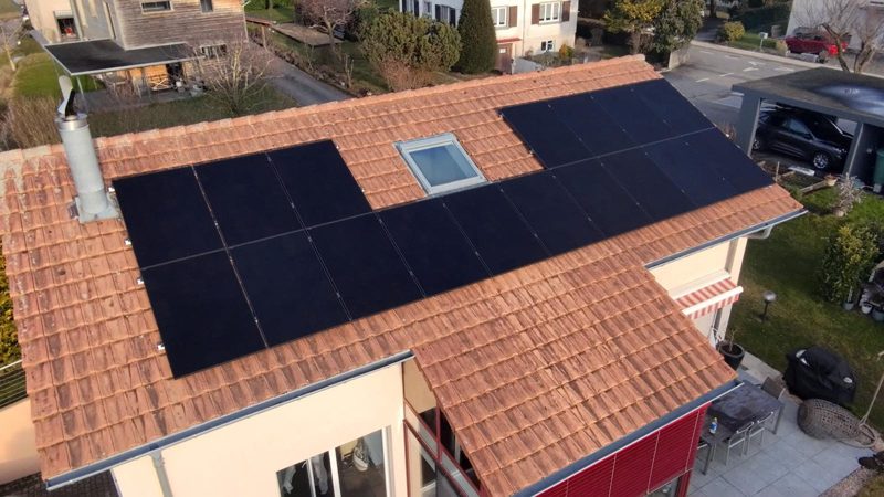 Vue aérienne du toit de Domdidier couvert de panneaux photovoltaïques noirs.