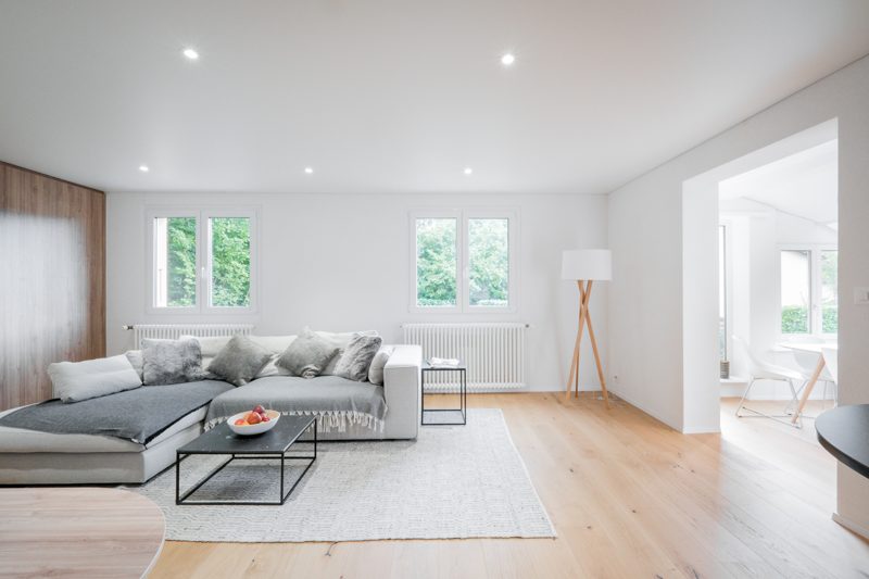 Le séjour rénové, parquet clair et murs blancs.
